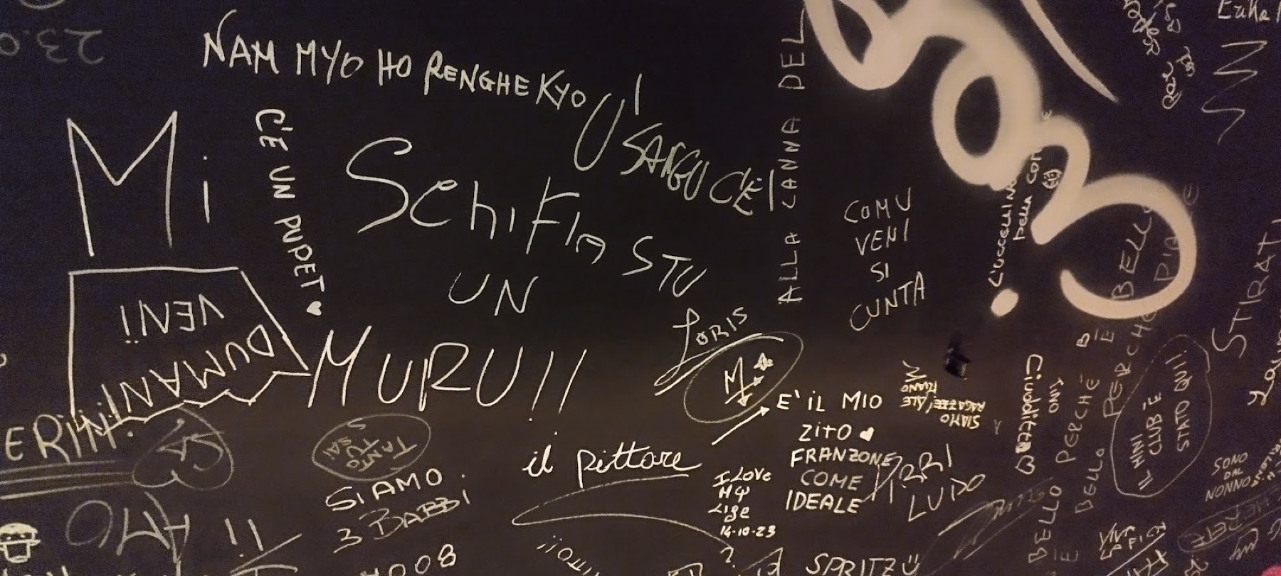 Il muro-lavagna della taverna, coperto di frasi e dediche lasciate dagli ospiti