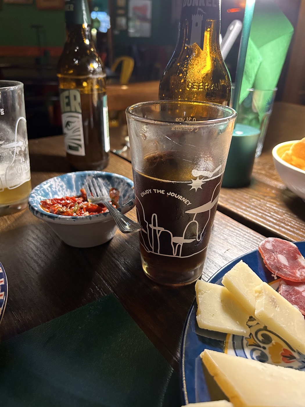 Un tagliere di formaggi e salumi con birra sul tavolo di legno della taverna